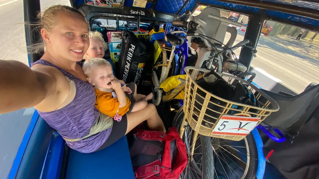 Familj i tuk-tuk med barn och cyklar, en del av en budgetresa i Thailand.
