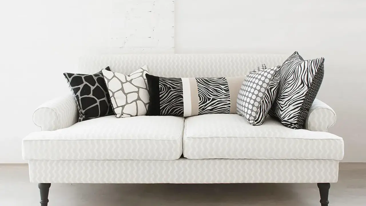 Ecco come mettere i cuscini sul divano: un mix di fantasie animalier e pois per un tocco selvaggio e moderno.
