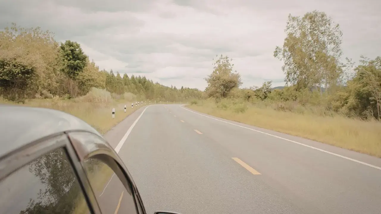 Vista desde un coche en una carretera rural. ¿Cuántos km dura un coche? Depende de su mantenimiento y el camino.
