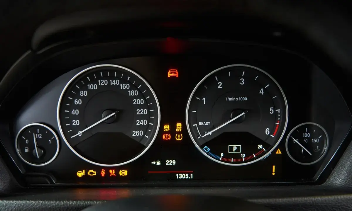 Cruscotto auto con tachimetro, contagiri e spie accese, tra cui il simbolo pressione gomme.