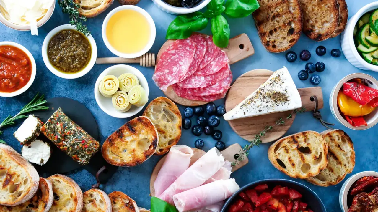 Eine köstliche italienische Vesperplatte mit Salami, Käse, Brot, Oliven und eingelegtem Gemüse.