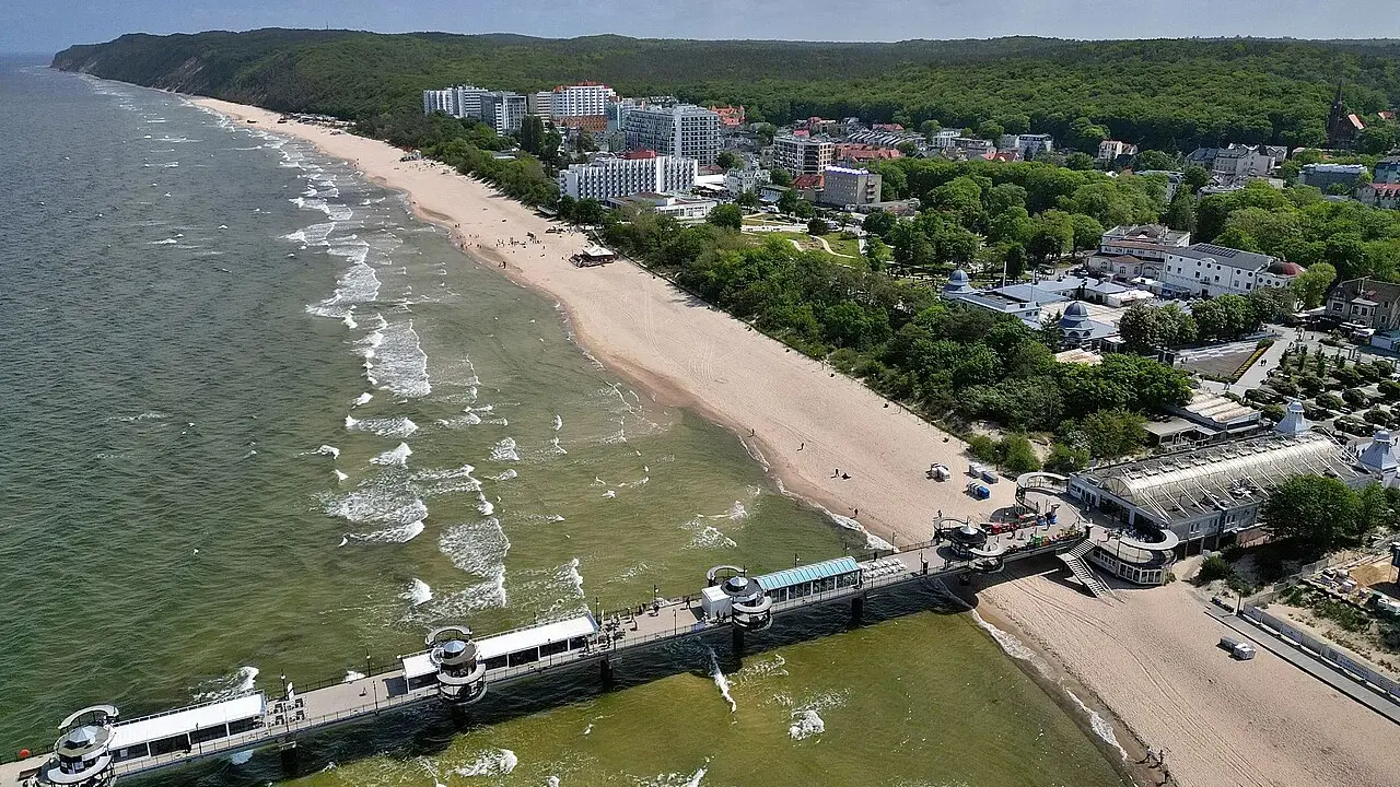 Miejscowości nad Bałtykiem na Pomorzu Zachodnim: plaża, molo, hotele i las.
