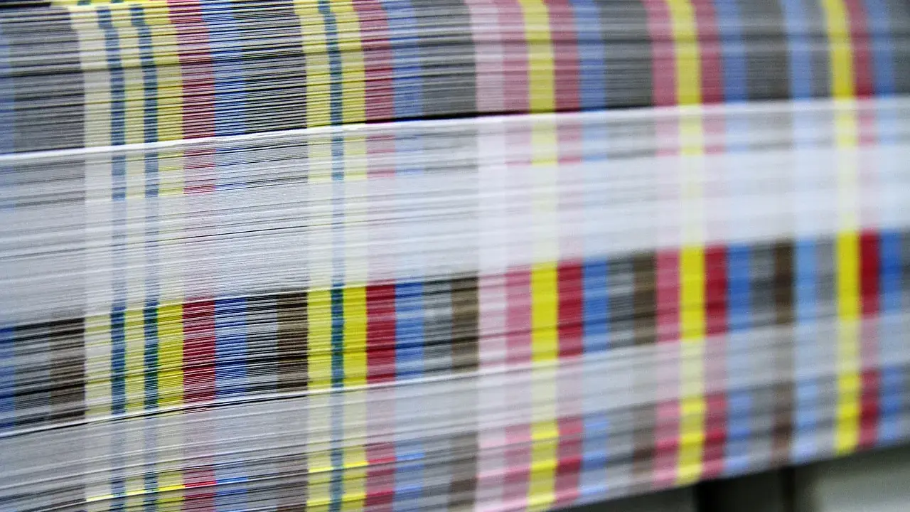 Kolorowe paski CMYK na krawędziach papieru świadczą o pracy w branży poligraficznej.