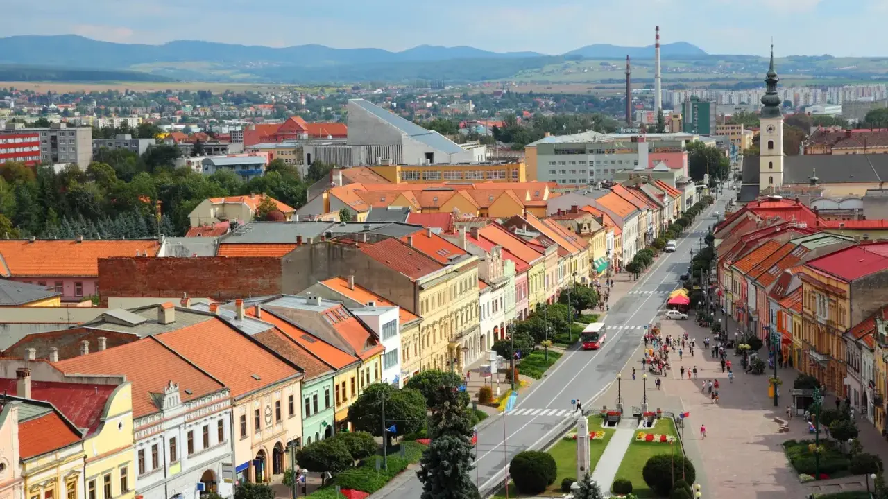 Widok na kolorowe kamienice wzdłuż ulicy, typowe dla największych miast Słowacji. W tle góry i zabudowania.