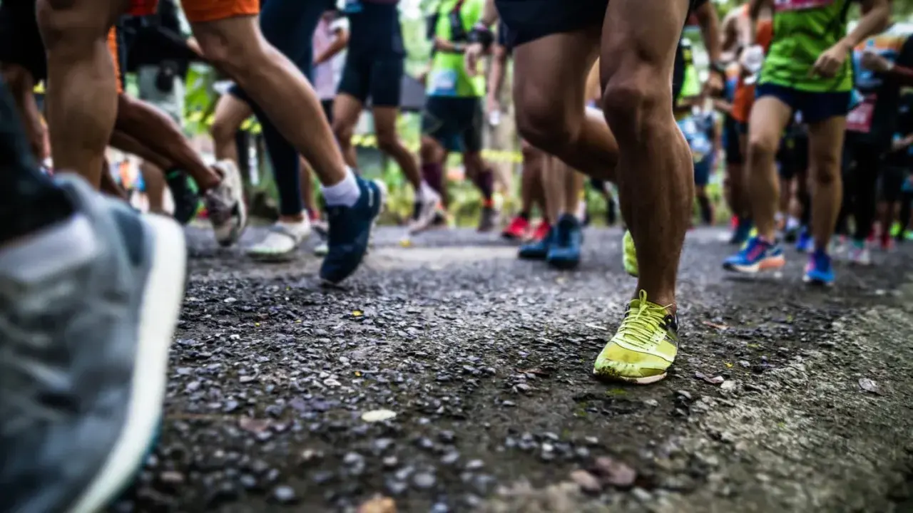 Läufer auf einer Strecke, die die halbmarathon distanz bewältigen. Fokus auf die Beine und Laufschuhe.