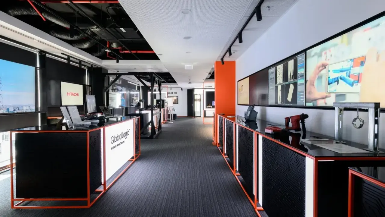 Nowoczesne biuro GlobalLogic, firmy z grupy Hitachi, z ekranami prezentującymi technologie.