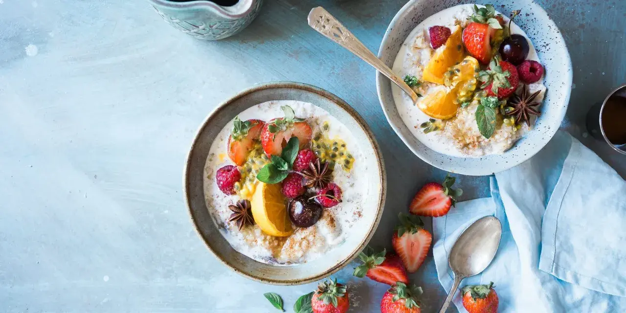 Zwei Schalen Haferbrei mit frischen Beeren, Orange und Passionsfrucht. Sanfte Kolitis ulcerosa Rezepte, die gut tun.