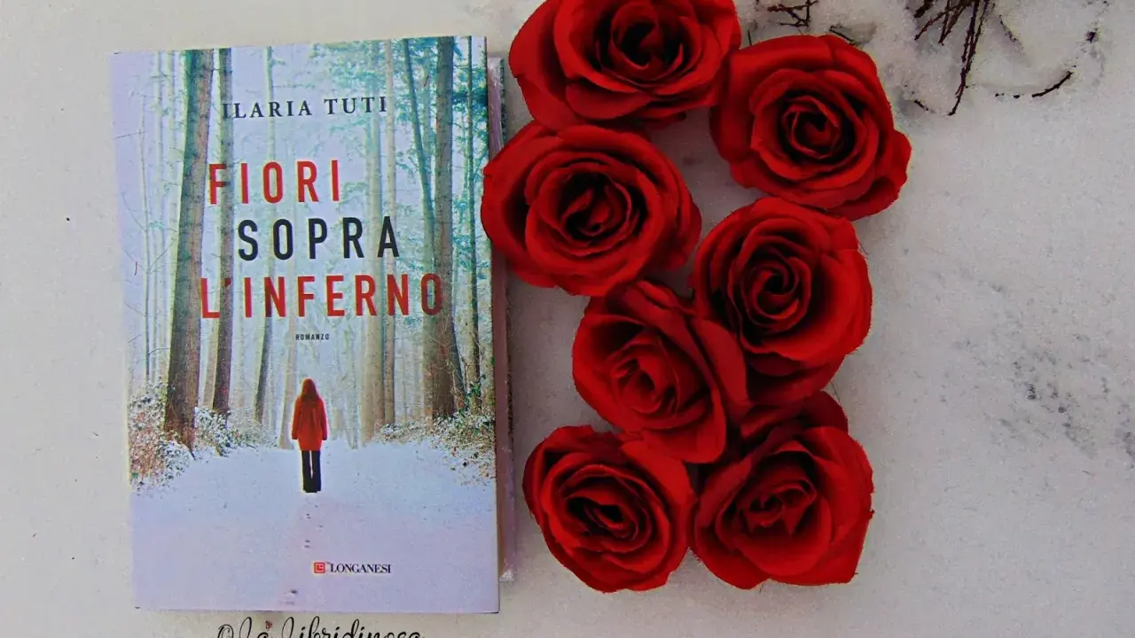 Copertina del libro "Fiori sopra l'inferno" di Ilaria Tuti, con rose rosse su sfondo innevato.