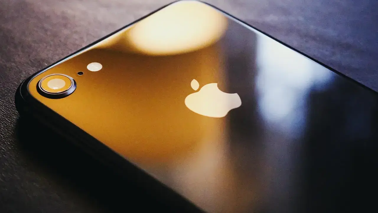Ciemny iPhone z logo Apple. Dowiedz się, jak zmienić Apple ID, aby zabezpieczyć swoje dane.