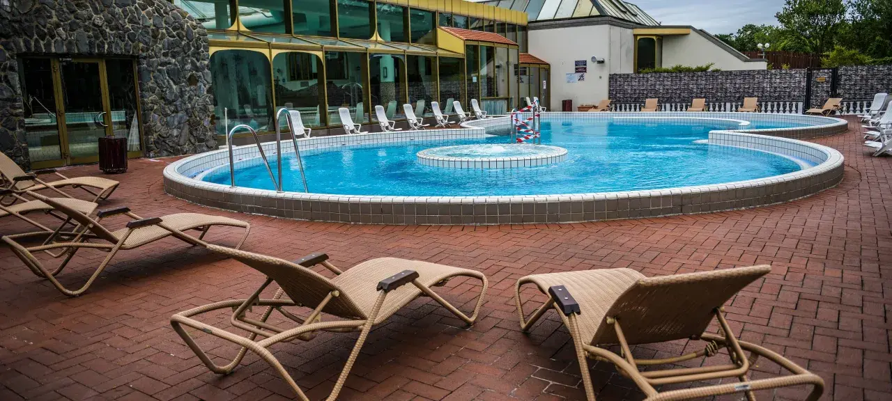 Entspannung pur an der Niederrhein Therme Mattlerbusch: Liegestühle laden zum Verweilen am blauen Pool ein.