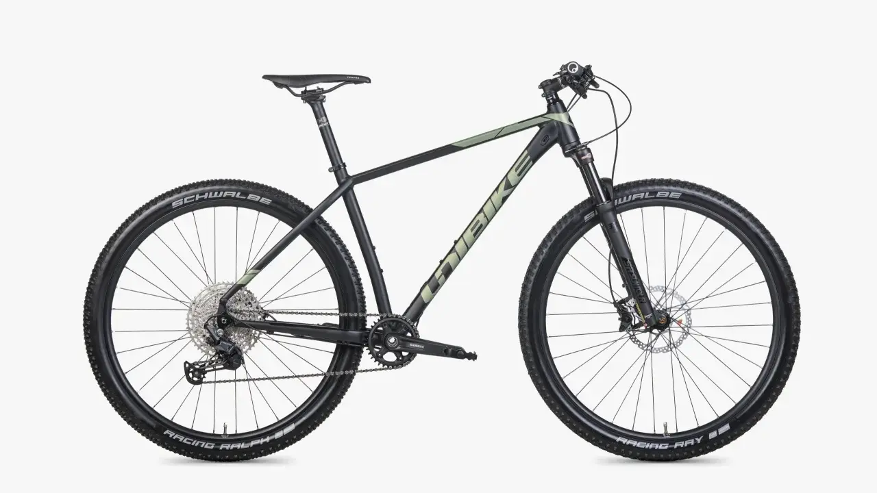 Czarny rower górski Unibike Evo z zielonymi akcentami, oponami Schwalbe Racing Ralph i Ray, gotowy na przygodę.