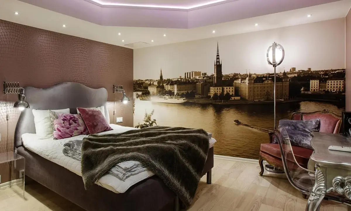 Ett mysigt rum med en stor säng och en fototapet av Stockholm. Perfekt för ditt vandrarhem i Sigtuna.