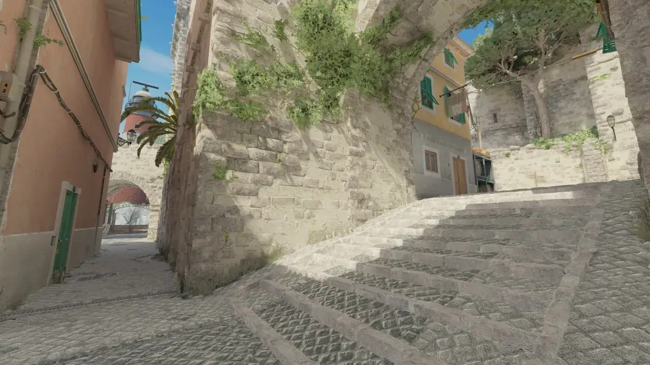 Kamienna ścieżka i schody w klimacie tuscan cs go, z widokiem na latarnię morską i budynki.