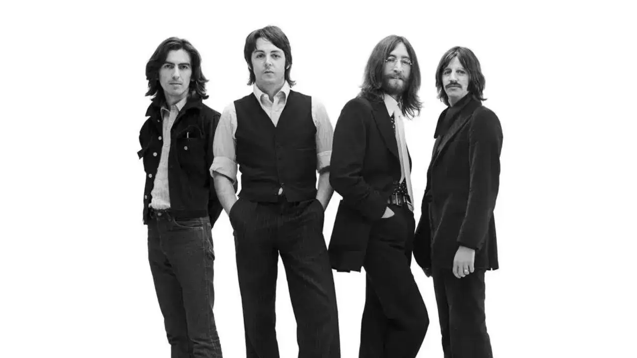 Les quatre membres des Beatles posent pour une photo en noir et blanc.