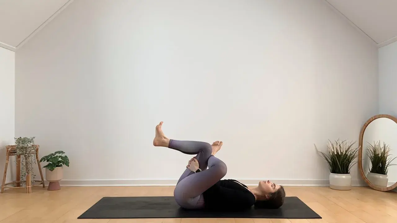 Frau in Yoga-Pose auf Matte, entspannt während ihrer Yoga-Periode.