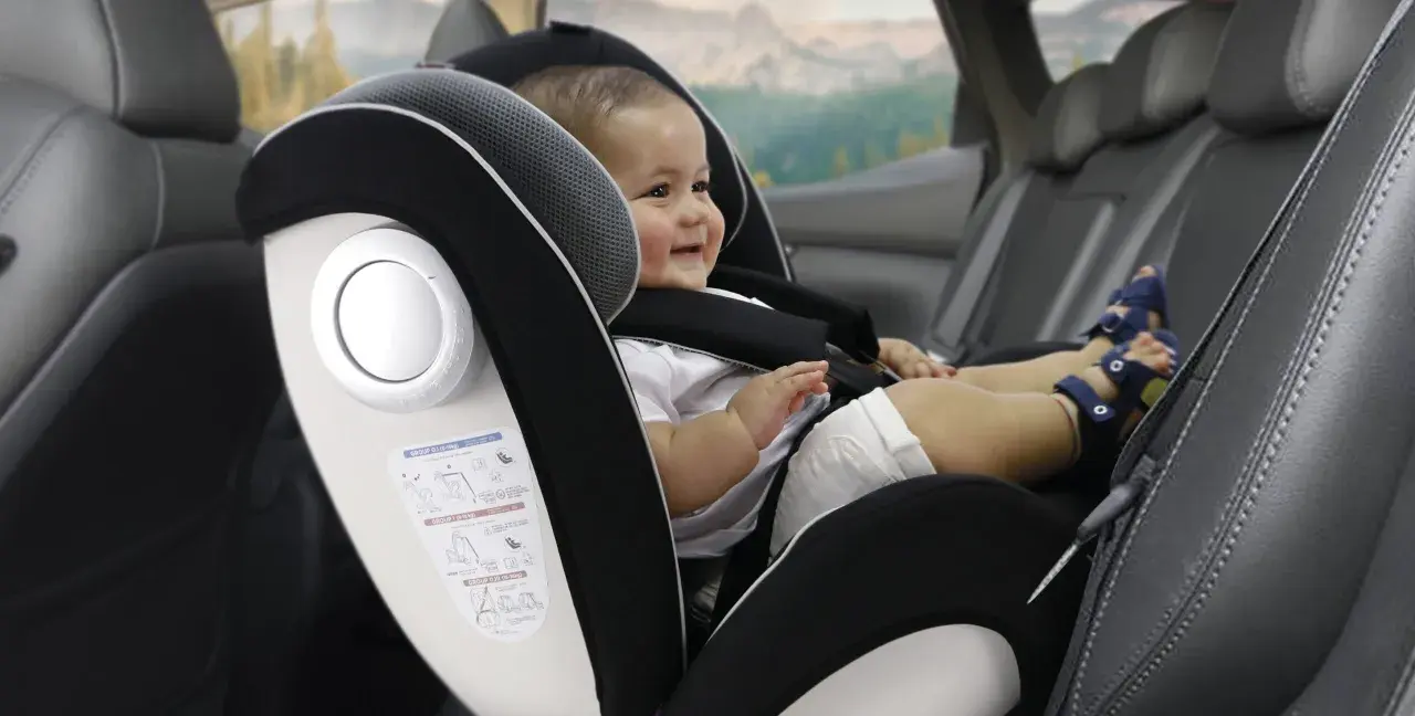 Bebé sonriente en silla de coche, grupo 0 hasta 18kg. Viaje seguro para los más pequeños.