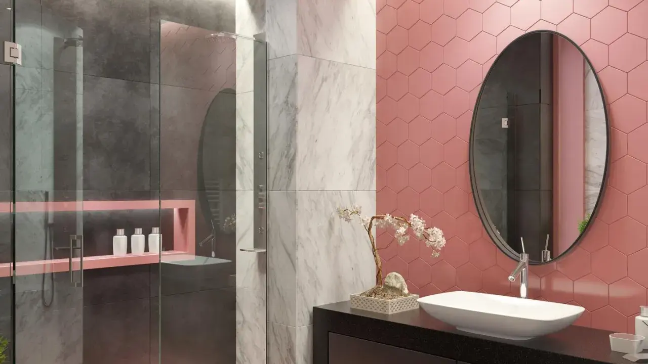 Bagno moderno con pareti rosa a nido d'ape, doccia in vetro e marmo. Un lavabo ovale su mobile nero e specchio rotondo completano le idee bagno rosa.