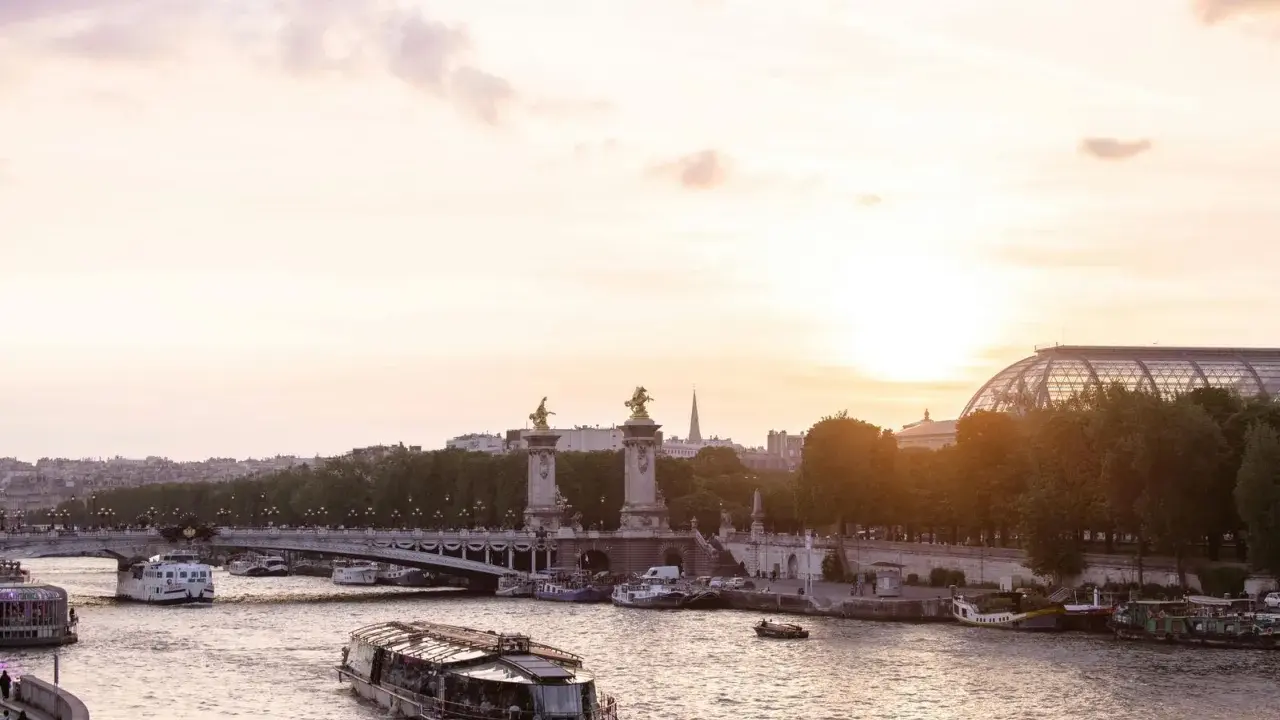 Boote auf der Seine bei Sonnenuntergang, eine malerische Szene, die die beste Reisezeit für Paris widerspiegelt.