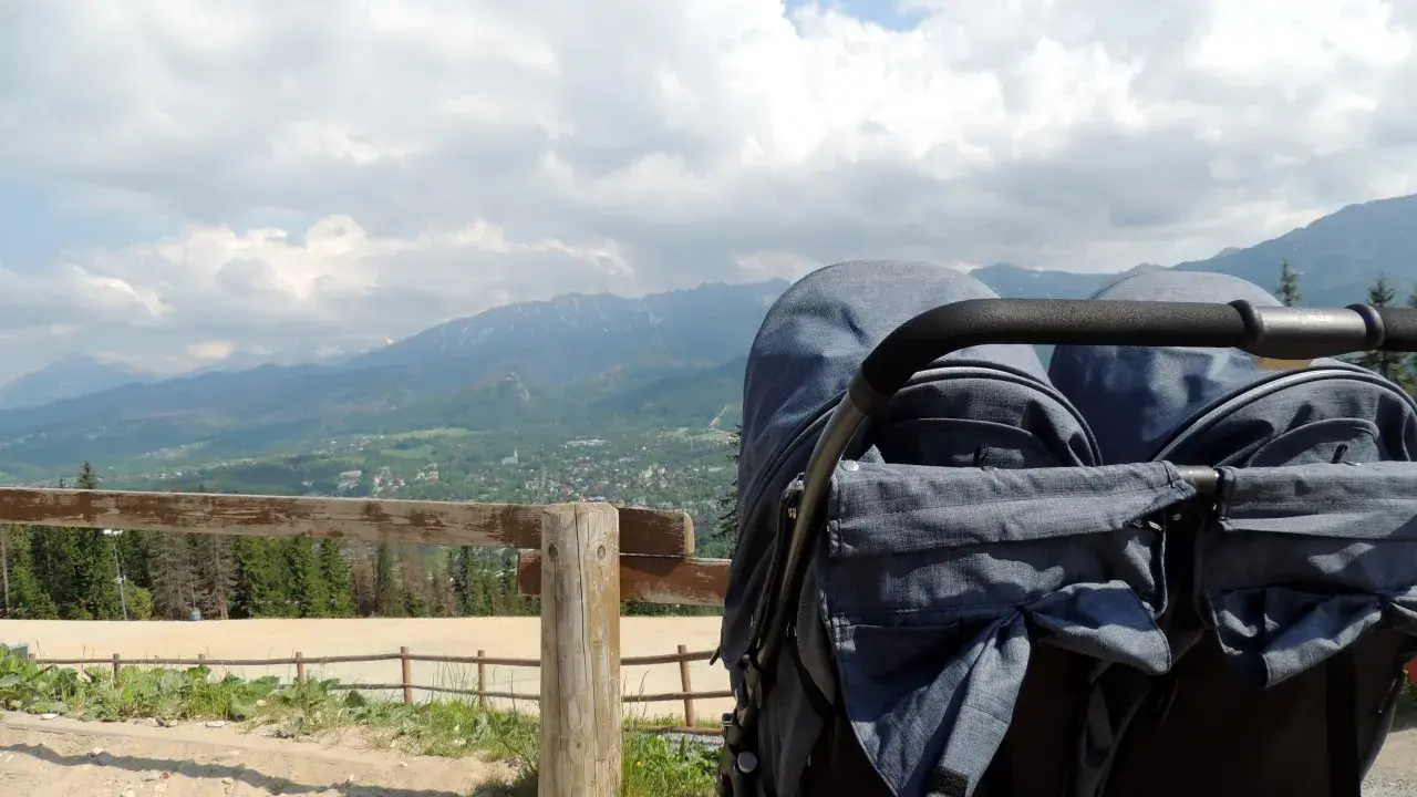 Podwójny wózek gotowy na przygodę. Zastanawiasz się, jakie szlaki z dzieckiem w Zakopanem są najlepsze? Ten widok na Tatry zachęca do odkrywania!