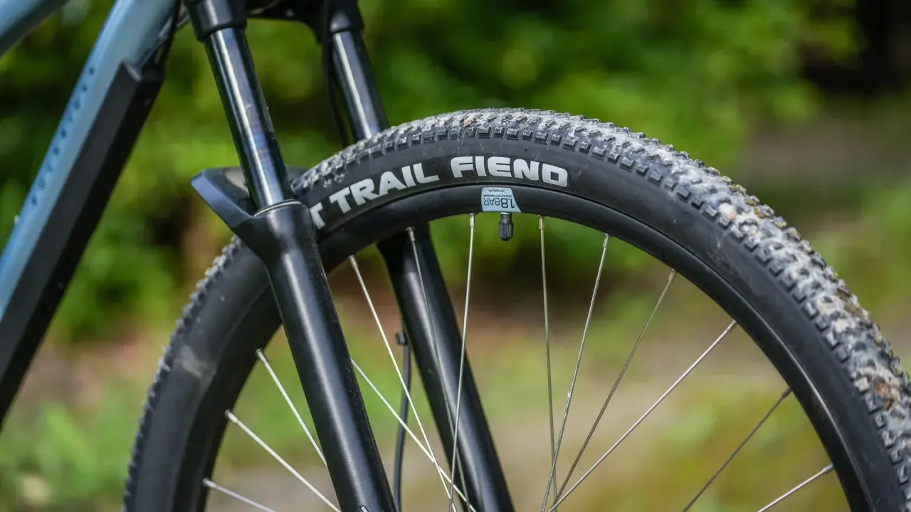 Opona rowerowa "Trail Fiend" z widocznym bieżnikiem, zwijana, gotowa na terenowe wyzwania.