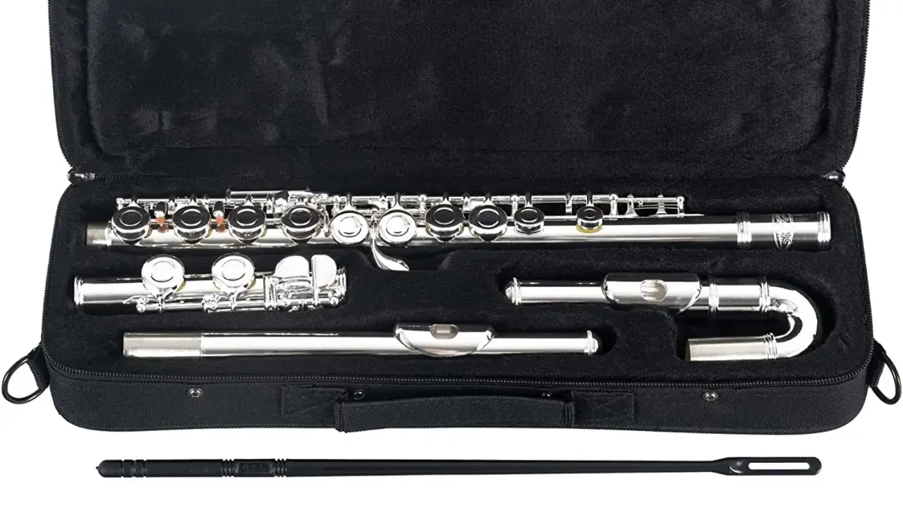 Étui ouvert noir contenant un instrument à vent argenté, une flûte traversière, ses pièces et accessoires de nettoyage.