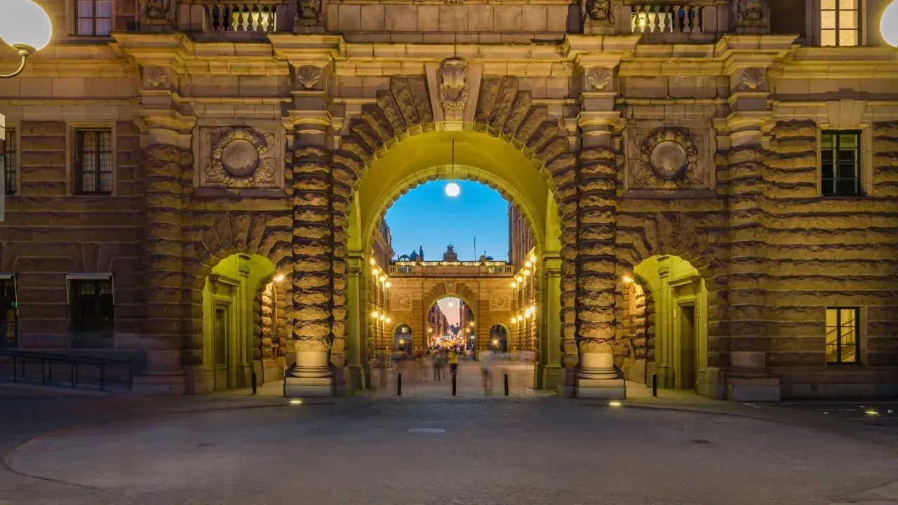 Imponujący łuk w Sztokholmie, idealne miejsce do zobaczenia. Wieczorne światła podkreślają kamienną architekturę i ruch uliczny.