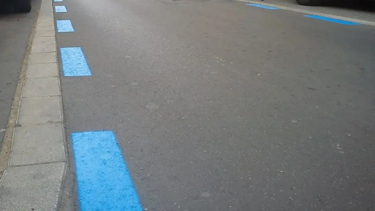 Marcas azules en el asfalto indican zona de aparcamiento regulado. Si no pagaste, así podrías saber si te han multado en zona azul.