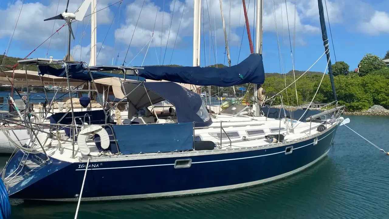 Voilier bleu "Iguana" au mouillage, sous un ciel bleu et nuageux. La magie du soleil sur l'eau, 44 avis.