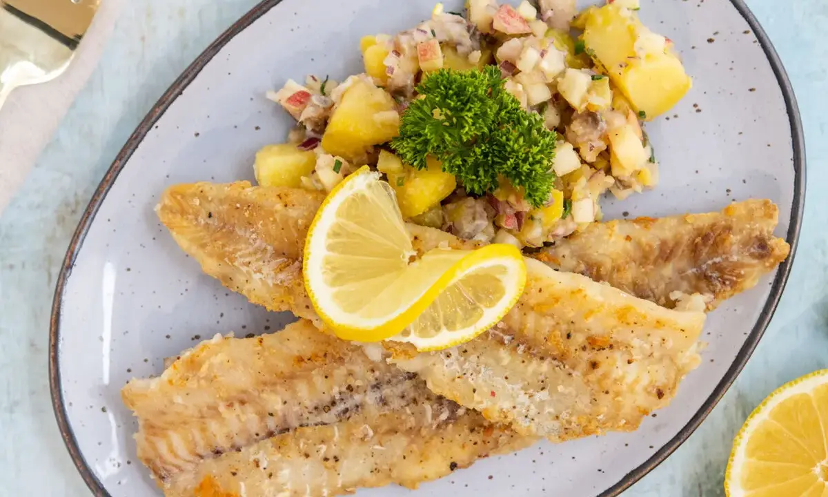 Gebratene Seelachsfilets mit Kartoffelsalat und Zitrone. Leckere Seelachsfilet Rezepte Pfanne für ein schnelles Abendessen.