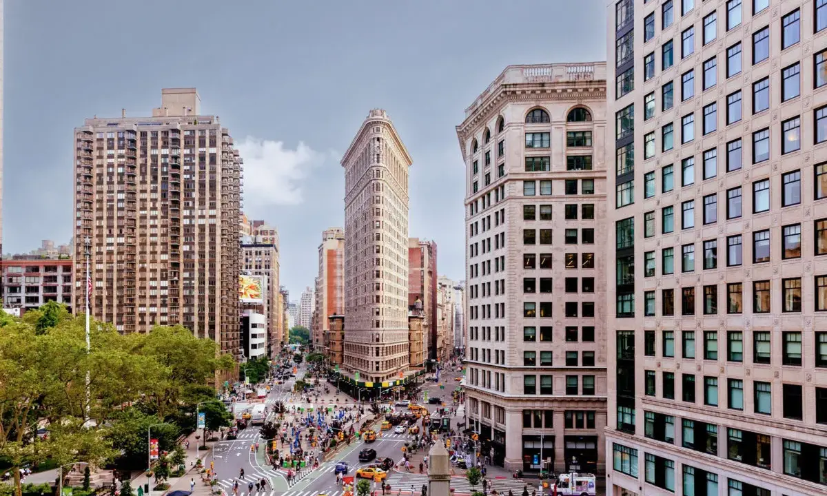 Vista aérea de Nueva York con el icónico edificio Flatiron en el centro. Los planos de la ciudad muestran la intersección de calles y la arquitectura circundante.