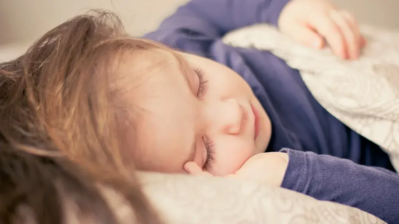 Dziecko śpi spokojnie, choć czasem **moczenie nocne na tle nerwowym** może zakłócać sen.