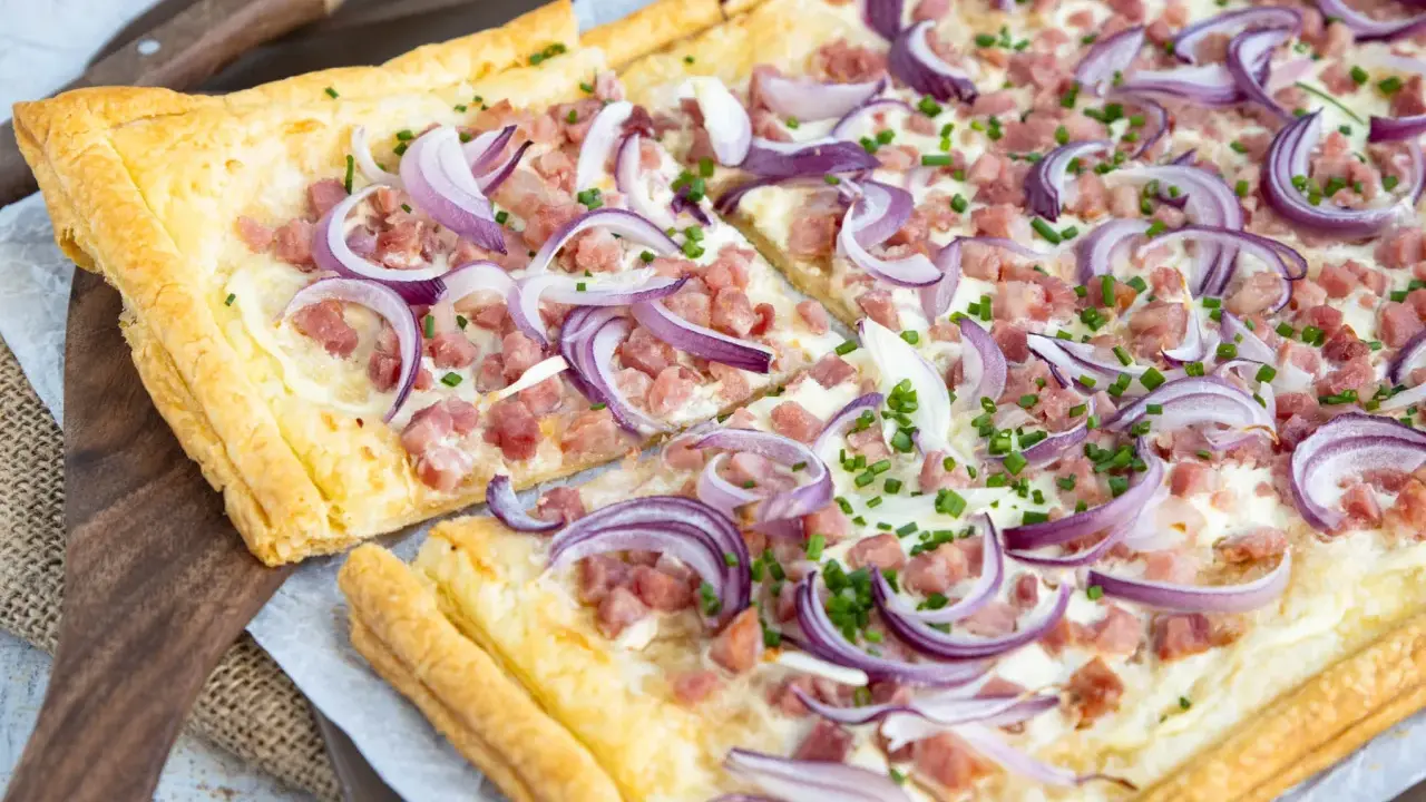 Flammkuchen varianten: knuspriger Teig mit Speck, Zwiebeln und Schnittlauch belegt.