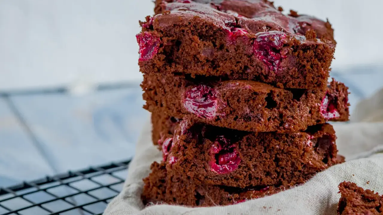Ein Stapel saftiger Schoko Kirsch Kuchen Blech Stücke mit saftigen Kirschen.