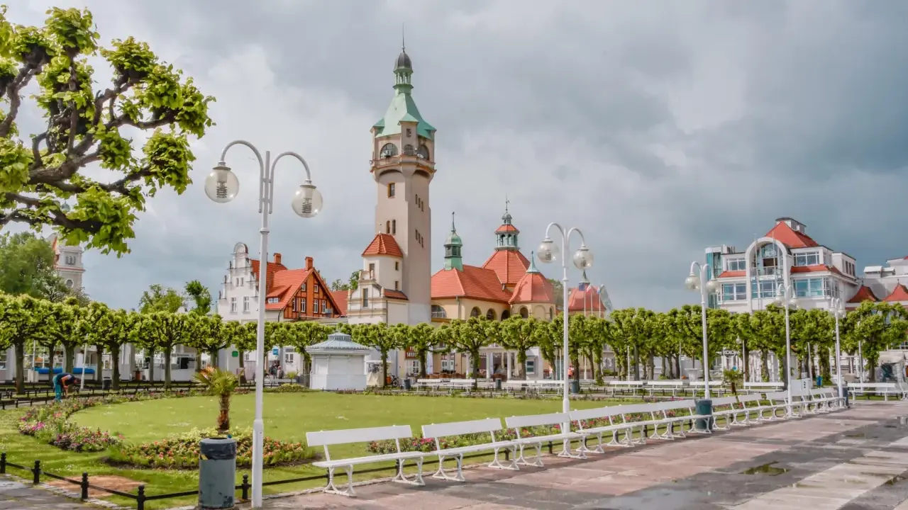 Malowniczy widok na deptak w Sopocie, z charakterystyczną wieżą i budynkami w stylu secesyjnym. Idealne miejsce na spacer między Gdańskiem a Gdynią.