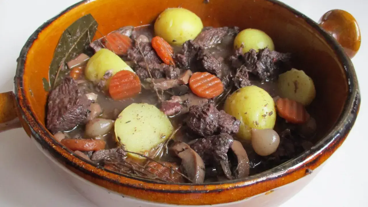 Un plat mijoté, spécialité culinaire Provence, avec du bœuf, des carottes, des pommes de terre et des oignons dans un jus savoureux.