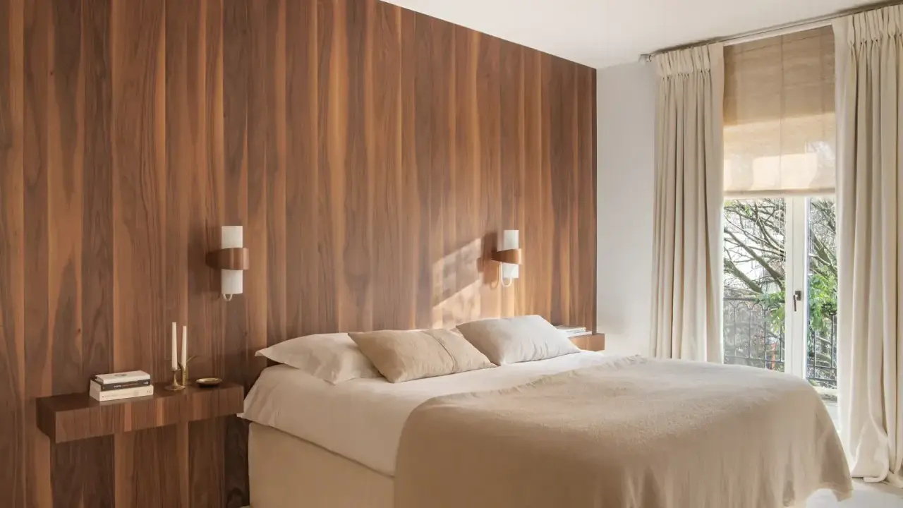 Dormitorio con cabecero de madera natural, creando un ambiente sereno y un cabecero feng shui. Cama confortable con mantas cálidas y luz tenue.