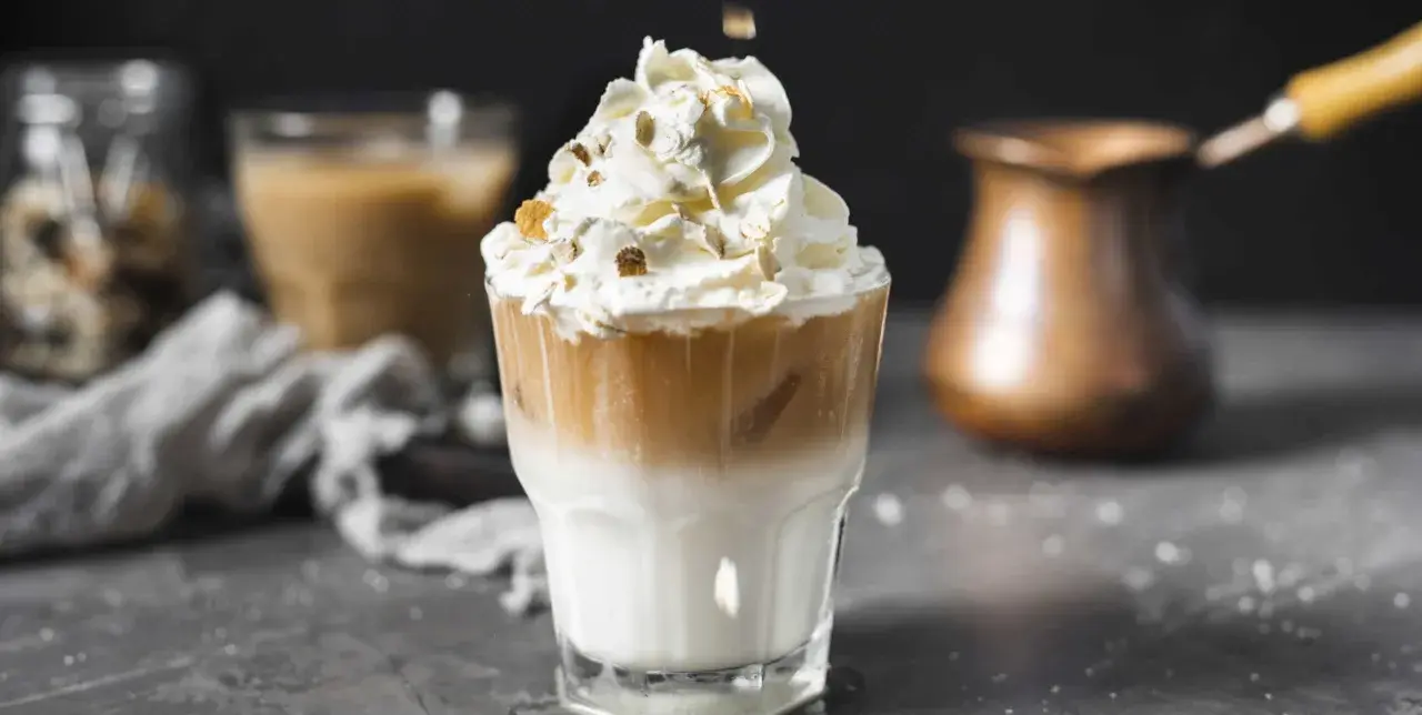 Un délicieux café liégeois, couronné de chantilly et de quelques éclats croquants, prêt à être dégusté.