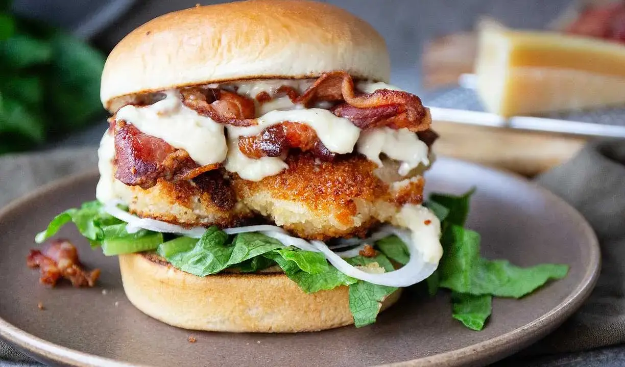 En saftig kycklingburgare med krispigt bacon, sallad, lök och en krämig dressing. Perfekt för ett gott hamburgerdressing recept.