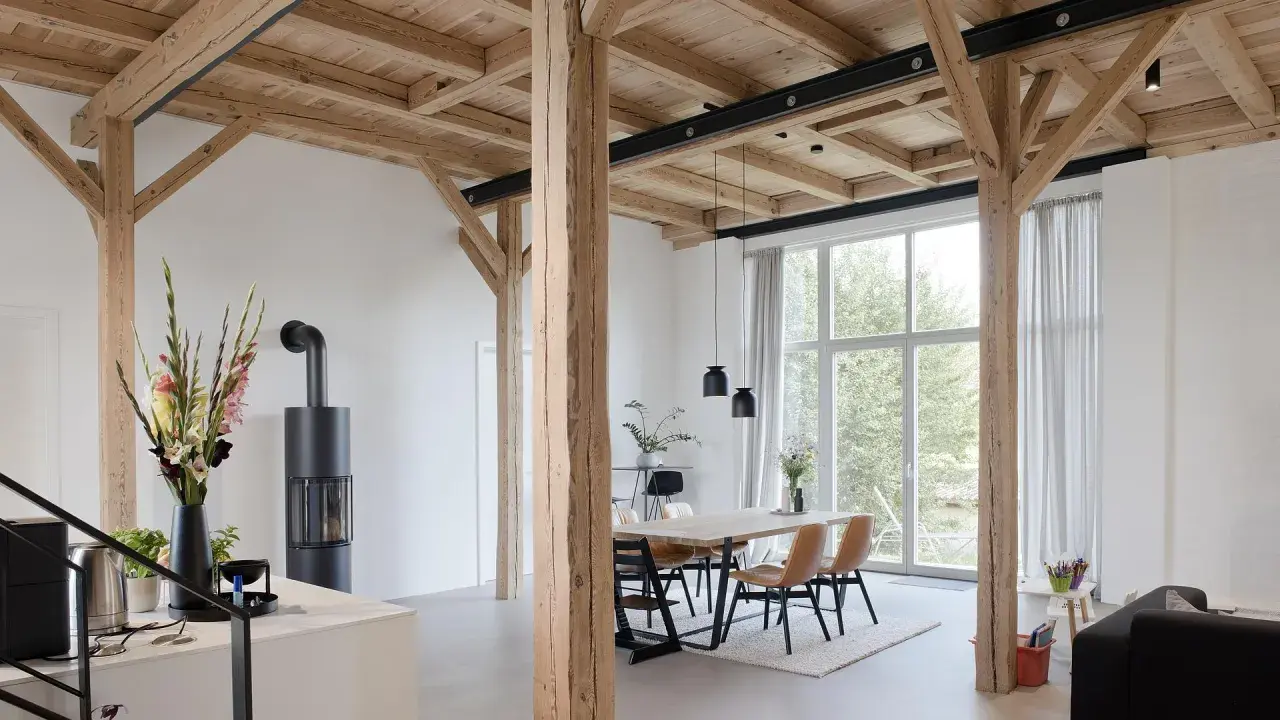 Moderne umgebaute Scheune mit Holzbalken und großem Fenster. Tolle Scheune umbauen Ideen für ein helles Wohnambiente.