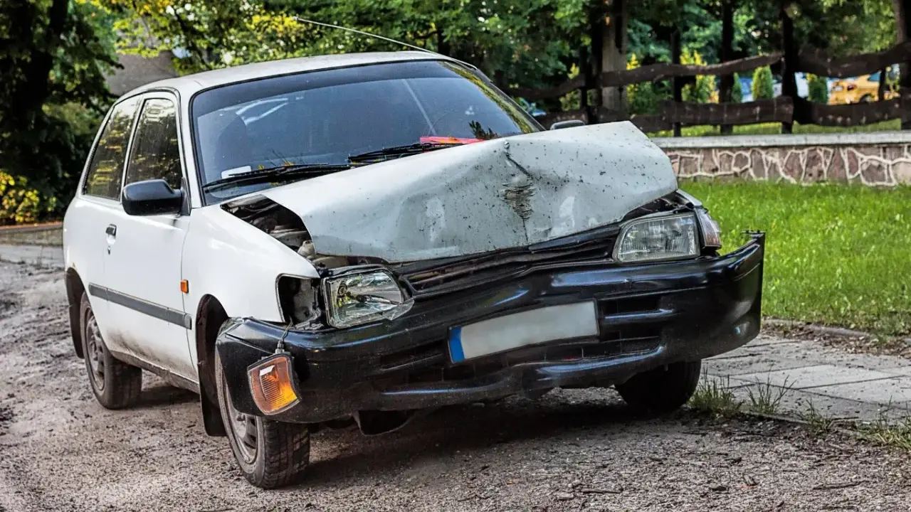 Uszkodzony biały samochód po wypadku. Zastanawiasz się ufg co to? To ubezpieczeniowy fundusz gwarancyjny, który pomaga w takich sytuacjach.