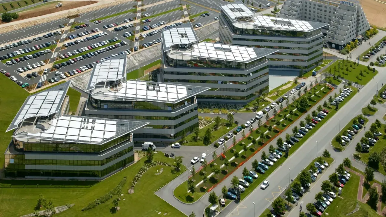 Vue aérienne de bâtiments modernes avec des parkings. On imagine un déjeuner d'affaires au restaurant La Javette.