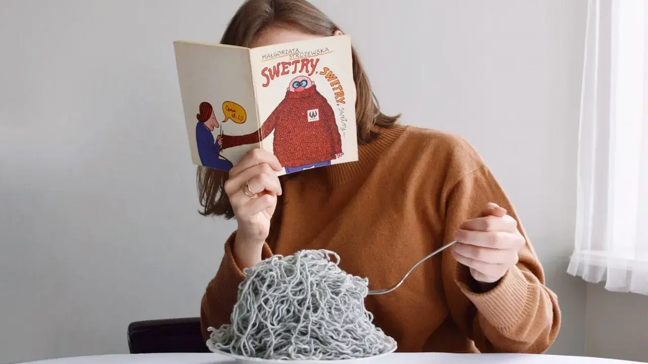 Dziewczyna czyta książkę o swetrach, jedząc spaghetti z włóczki. Jak znaleźć początek włóczki?