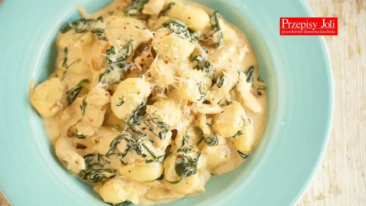 Pyszne gnocchi z kurczakiem i szpinakiem w kremowym sosie, posypane parmezanem. Idealne danie na szybki obiad.