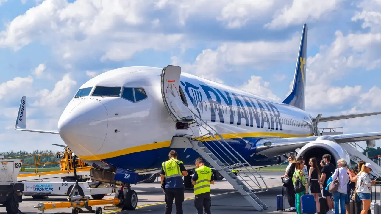 Samolot Ryanair na płycie lotniska z pasażerami i obsługą.