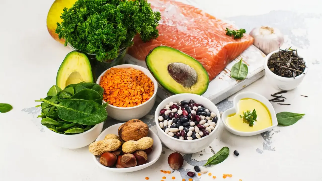 Zdrowe składniki na dietę na cholesterol: łosoś, awokado, szpinak, soczewica, fasola, orzechy, oliwa z oliwek, czosnek, jabłko, natka pietruszki.