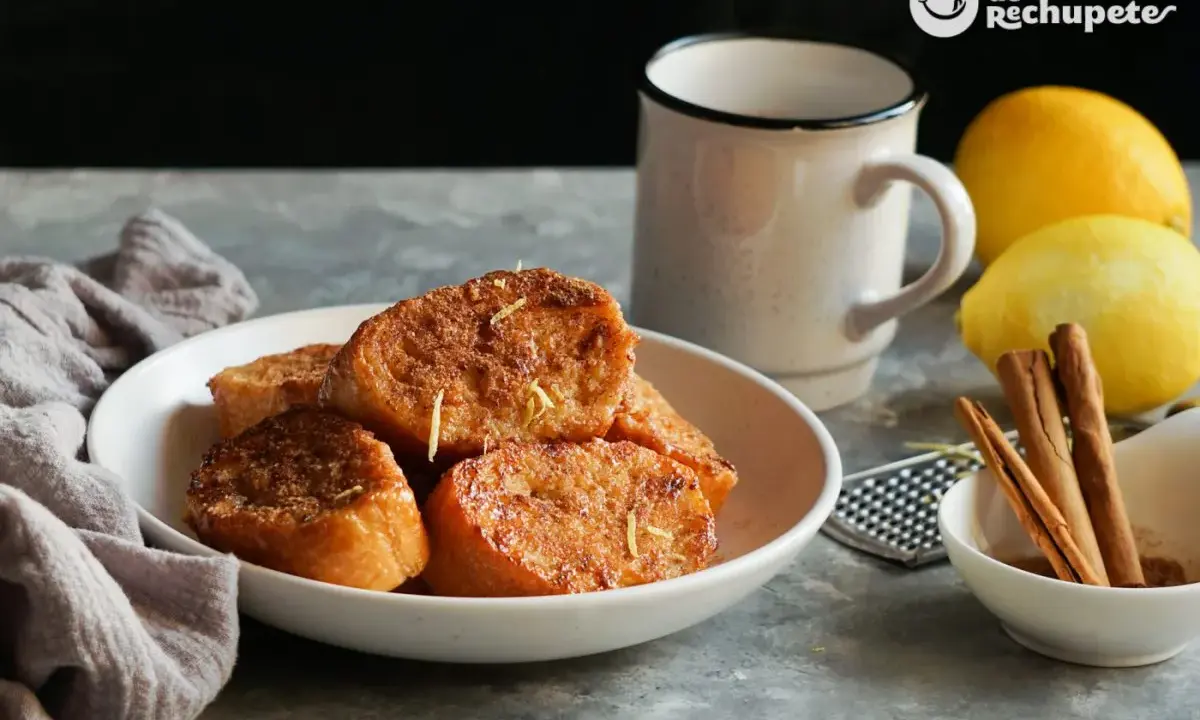 Torrijas de pan doradas y crujientes, espolvoreadas con ralladura de limón. Un clásico de las recetas de torrijas de pan, perfecto para disfrutar.