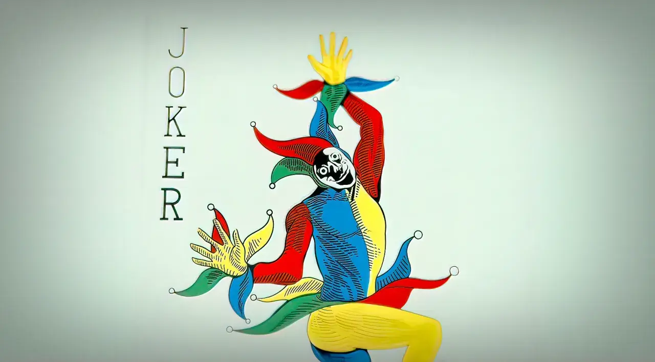 Karta joker w jaskrawych kolorach, z uśmiechniętą twarzą i charakterystycznym nakryciem głowy.