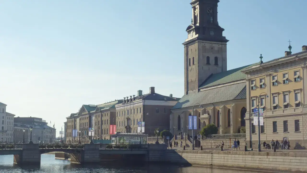 Goteborg, Szwecja. Przewodnik po mieście: kanał, most, zabytkowe budynki i wieża kościelna.