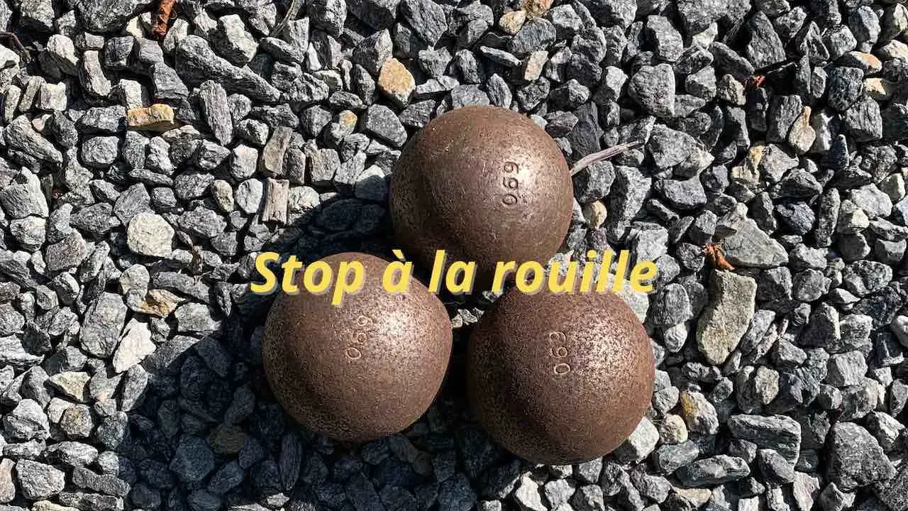 Trois boules de pétanque rouillées sur des graviers. Apprenez comment nettoyer des boules de pétanque pour qu'elles retrouvent leur éclat.