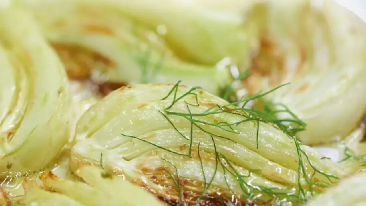 Gegrillte Fenchelspalten mit frischem Dill garniert, ein köstliches Gericht, das zeigt, wie man Fenchel zubereiten kann.